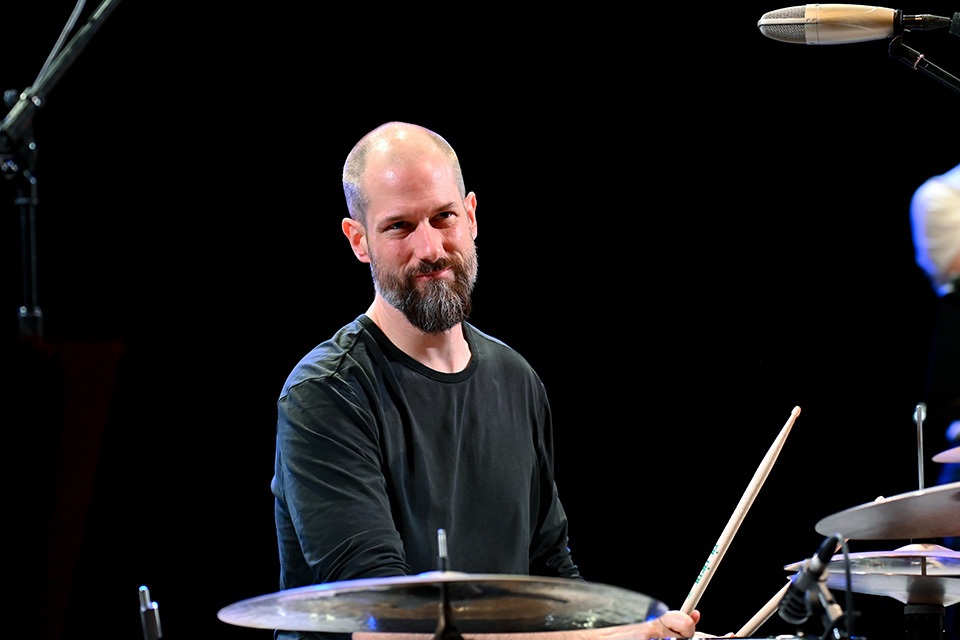 Benny Greb playing the drum kit and smiling